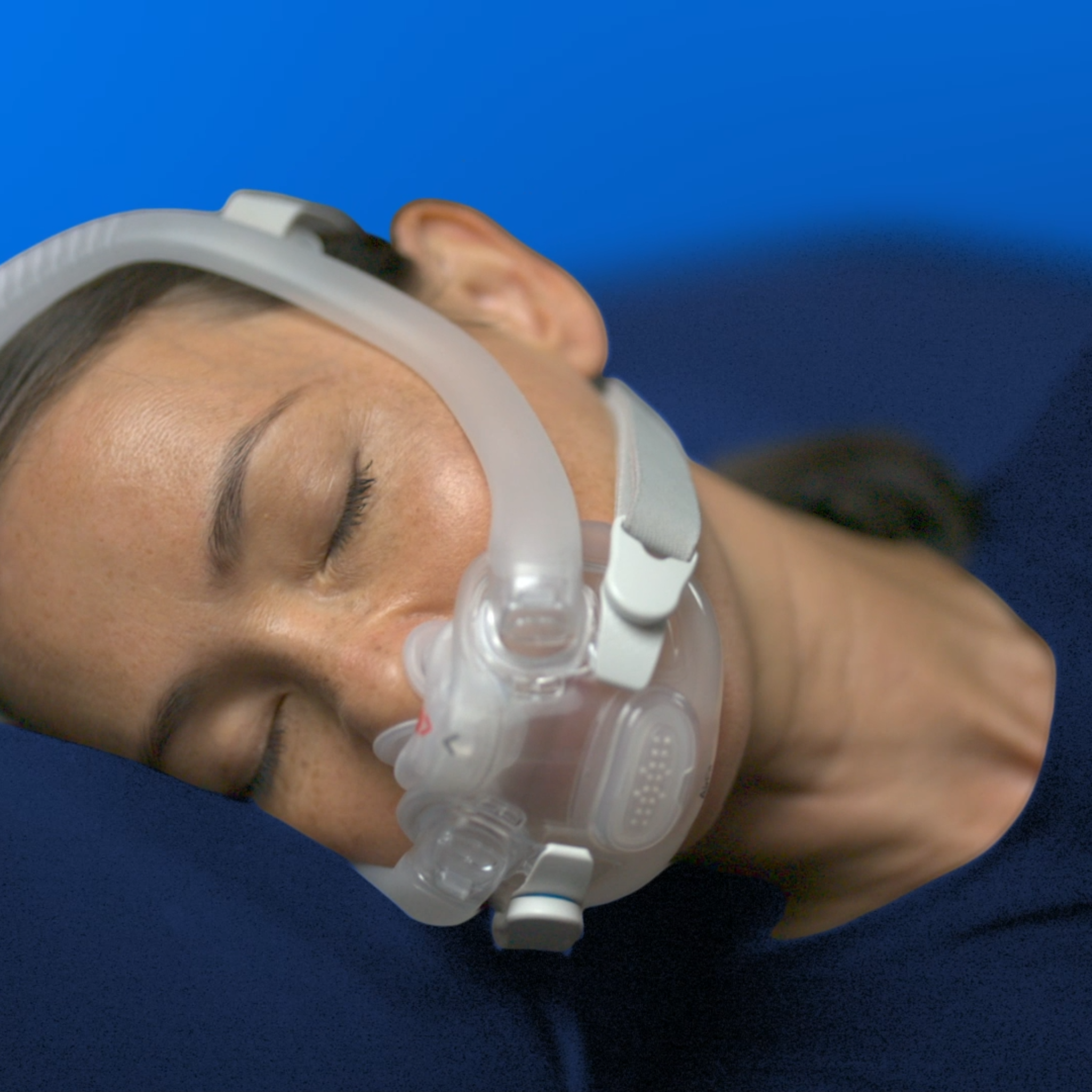 Woman sleeping soundly wearing the AirFit X30i oral nasal mask