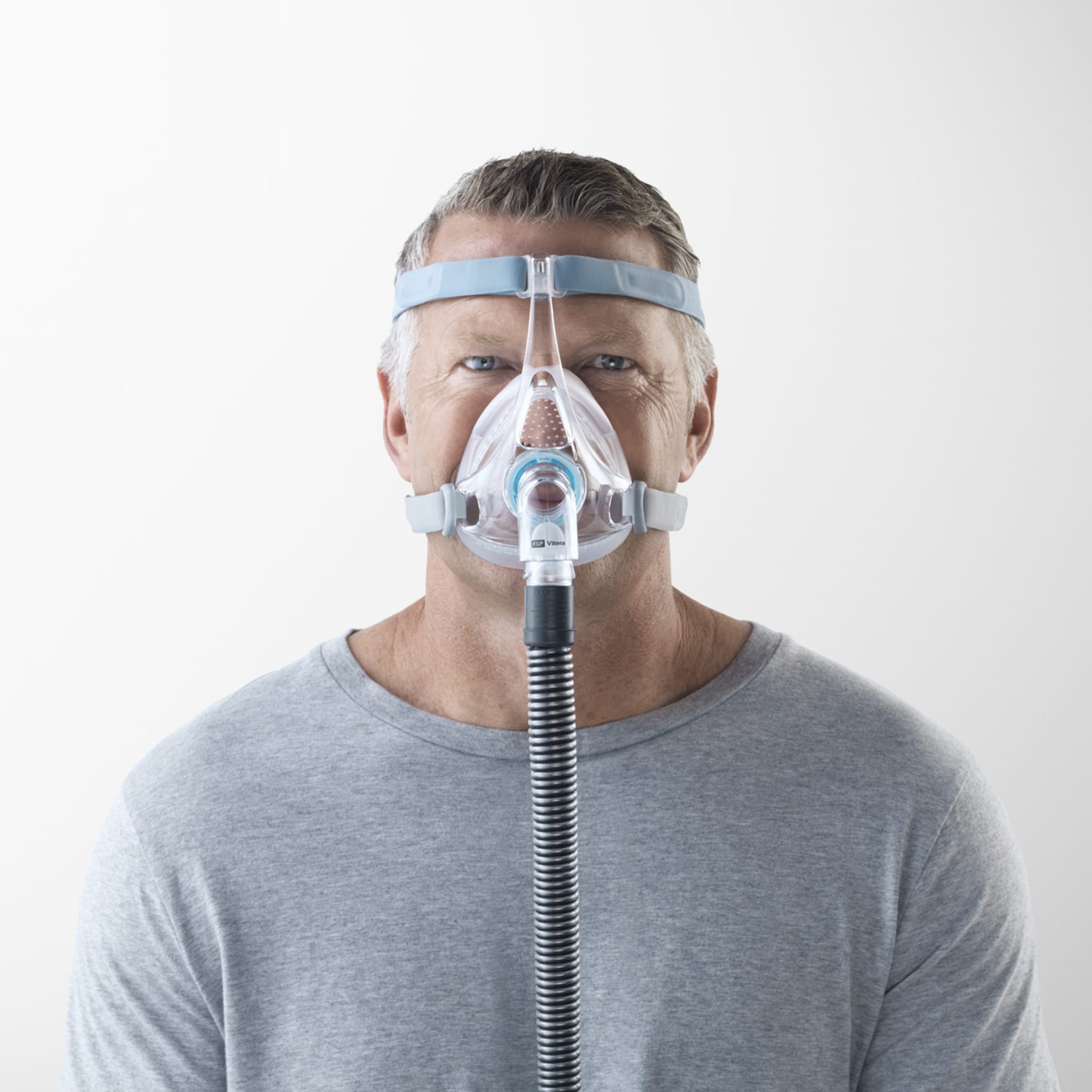man wearing f&p vitera full face cpap mask, facing the camera