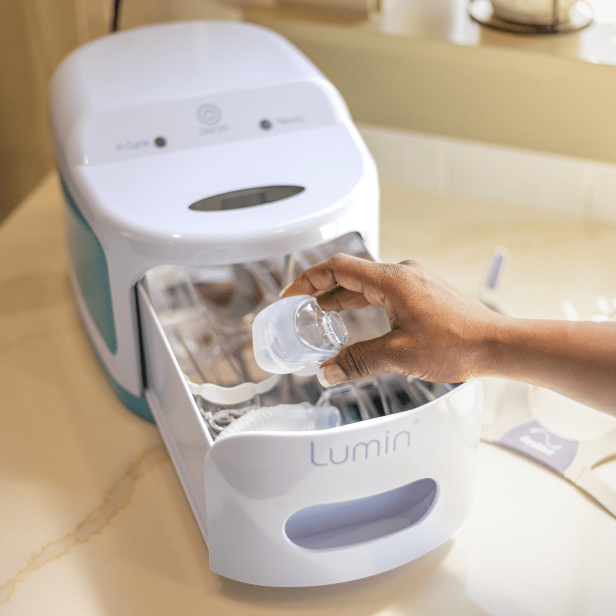 a hand places an airfit n20 cushion into the lumin's sanitizing chamber
